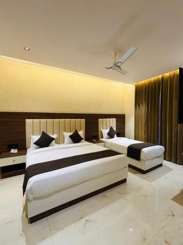 a hotel room with two beds and a ceiling at Hotel Hrishikesh High Tapovan in Rishīkesh