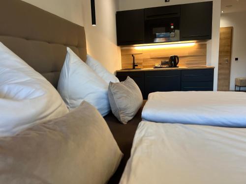 a hotel room with two beds with pillows and a television at Goldhirsch Aparthotel in Wagrain