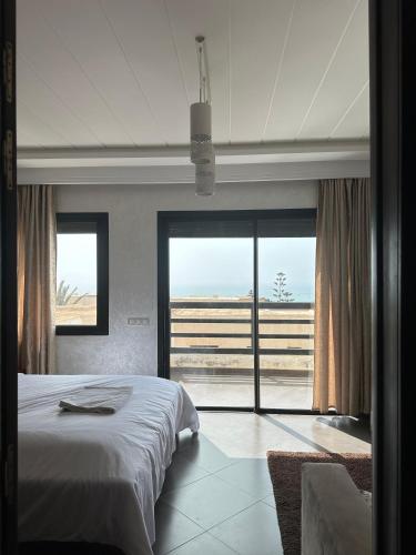 a bedroom with a bed and a view of the ocean at Villa Aglou Center Near Mirlaft in Zaouia Sidi Ouaggag