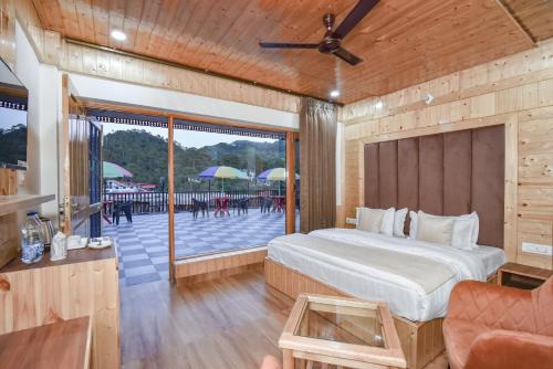 a bedroom with a bed and a patio with umbrellas at Hotel Dalhousie Delight in Dalhousie