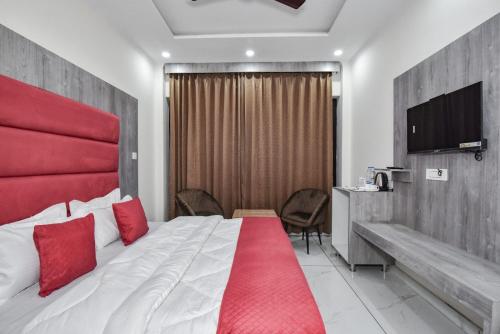 a hotel room with a large bed with red pillows at Hotel Dalhousie Delight in Dalhousie