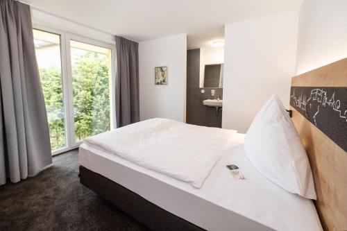 a hotel room with a bed and a window at Hirsch - Das Ellwanger Landhotel in Ellwangen