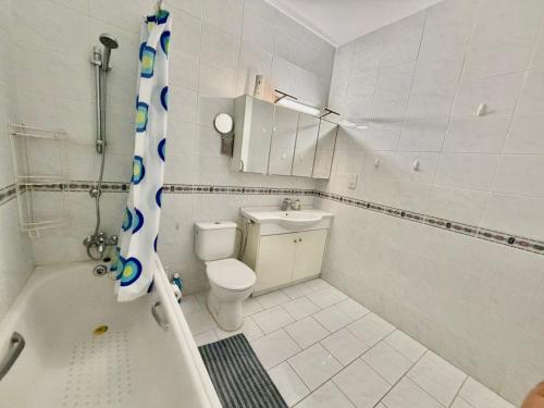a white bathroom with a toilet and a shower at Bayview Terraces Cozy 1BR Haven in Limassol