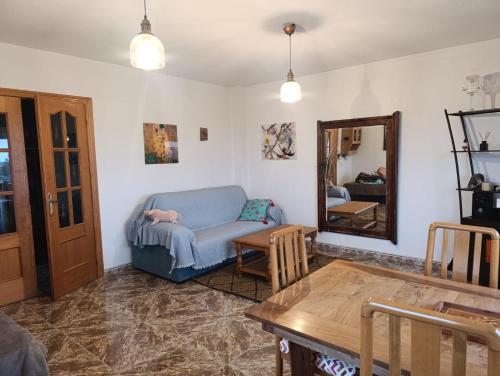 a living room with a blue couch and a mirror at La Casuca in El Pelayo