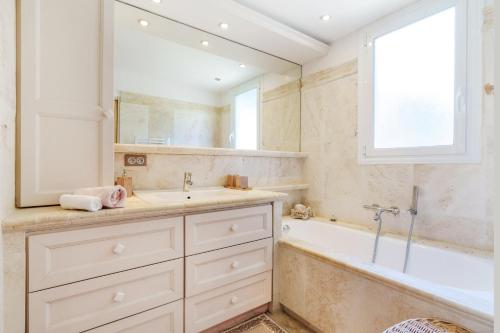 a bathroom with a tub and a sink and a mirror at Appartement Centre de Saint-Tropez in Saint-Tropez