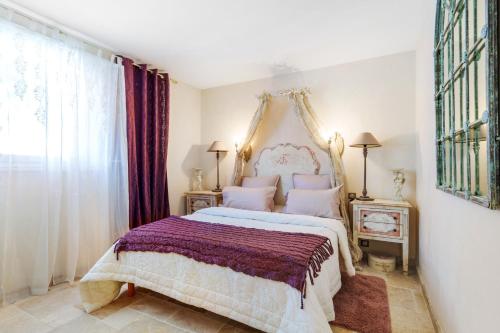 a bedroom with a large bed with a purple blanket at Appartement Centre de Saint-Tropez in Saint-Tropez