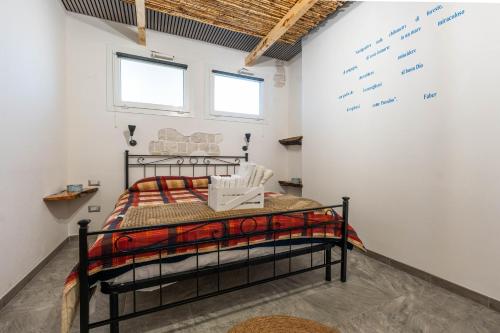 a bedroom with a black bed and a white wall at Kasa Kalagonis in Maracalagonis