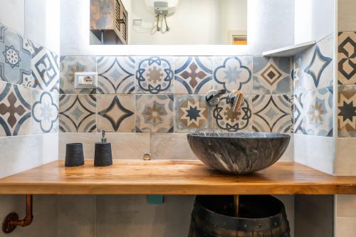 a bathroom with a bowl sink on a wooden counter at Kasa Kalagonis in Maracalagonis