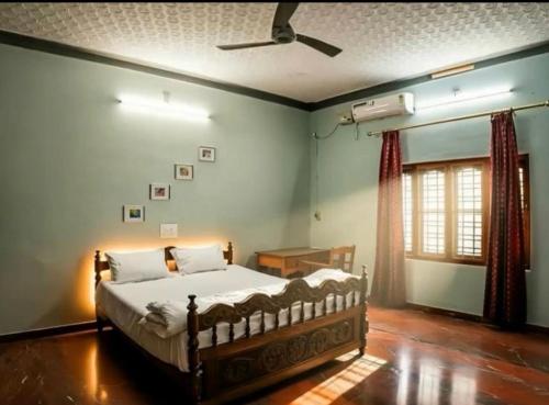 a bedroom with a bed and a ceiling fan at Athira Homestay in Kollengode
