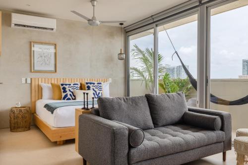 a living room with a bed and a couch at Hola Donceles Suites in Cancún