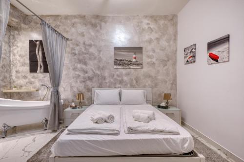 a white bedroom with a bed and a bath tub at Staytopus St Elizabeth - Modern Apartment - in Xewkija