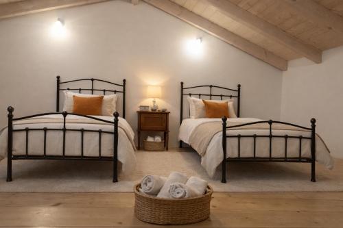 zwei Betten in einem Schlafzimmer mit einem Korb Handtücher in der Unterkunft Elichrysos house in Kagkátika