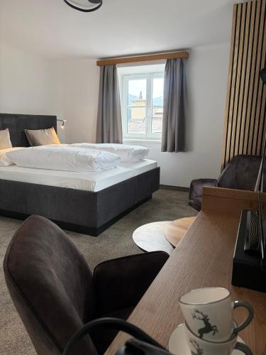 a bedroom with a bed and a table and chairs at Pension Schiessling in Anif