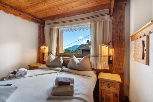 a bedroom with two beds and a large window at Affittacamere De Charme Jour Et Nuit in Torgnon