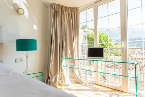 a bedroom with a bed and a window with a laptop at Apartments Captain's Villa in Budva