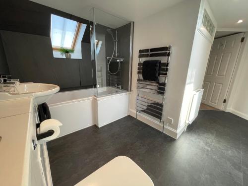 a white bathroom with a shower and a sink at Forth, Pittenweem in Pittenweem