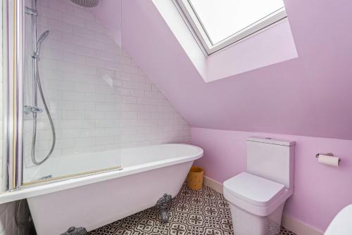 a bathroom with a toilet and a bath tub at Saoirse in East Wittering