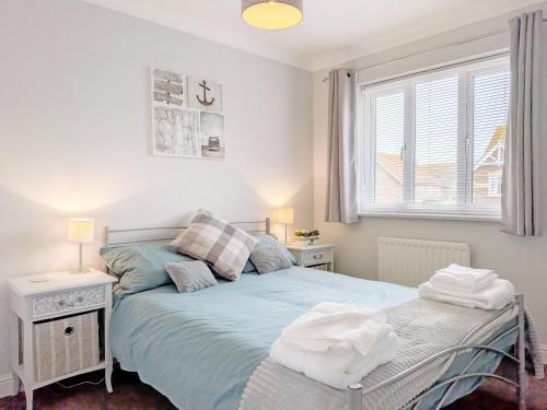 a bedroom with two beds and a window at Shell Seekers - Selsey in Selsey