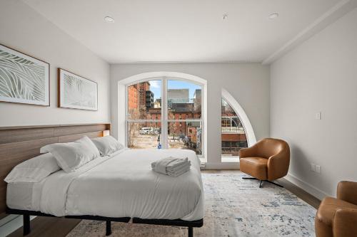 a bedroom with a bed and a chair and a window at Le Nomade Quartier Chinois in Montreal