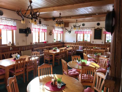 an empty restaurant with wooden tables and chairs at Penzion Alenka in Špindlerův Mlýn