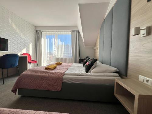 a bedroom with a large bed with a window at WiLLA APART in Władysławowo