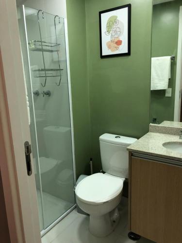 a bathroom with a toilet and a glass shower at Studio Praça Tatuapé in São Paulo