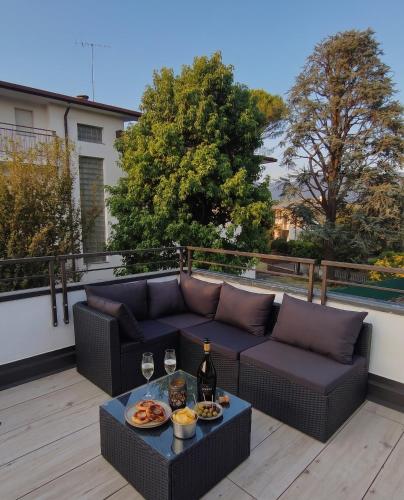 a patio with a couch and a table with wine glasses at LA TERRAZZA - Very Quiet - Free park - 3 min from Varese center and lake - AIR Conditioning - Cycling friendly in Varese