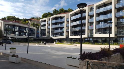 a parking lot in front of a large apartment building at Apartments Grbic in Mlini