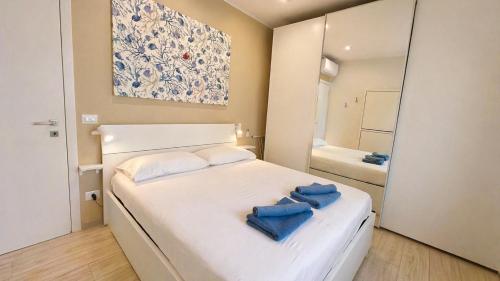 a small bedroom with a white bed with blue towels on it at BiloVarazze with Terrace in Varazze
