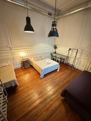 a bedroom with two beds and two pendant lights at Casamor in Buenos Aires