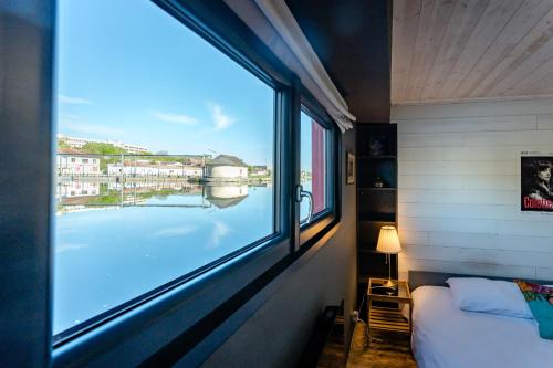 a bedroom with a window with a view of the water at Ainos Louanges - Bail Partner in Auxerre