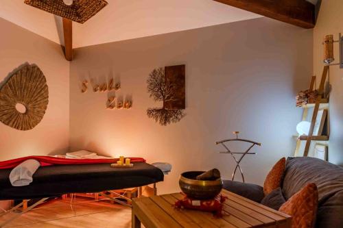 a living room with a couch and a table at L'Escale Sud Gironde - Séjour en amoureux avec jacuzzi privatif - Piscine - Massage Traiteur & Brunch possibles in Pompéjac