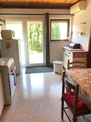 a room with a kitchen with a refrigerator and a table at Maison Schmidt in Oderen