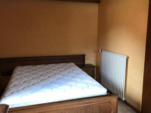 a bed in a bedroom next to a radiator at Maison Schmidt in Oderen