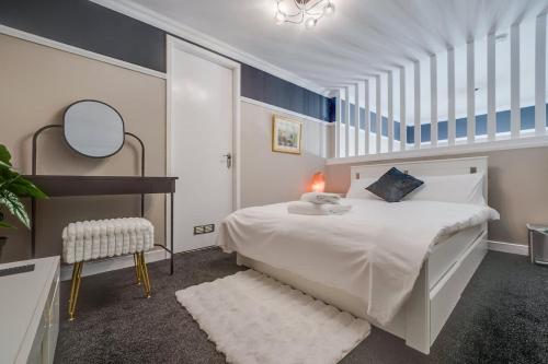 a bedroom with a large white bed and a chair at Luxurious Royal 2BR Apartment, Glasgow City Centre in Glasgow