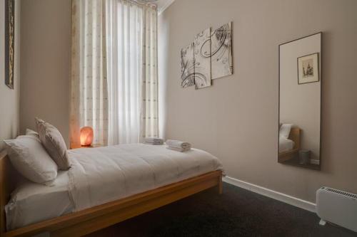 a bedroom with a large bed with a window at Luxurious Royal 2BR Apartment, Glasgow City Centre in Glasgow