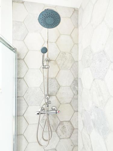 a shower with a shower head in a bathroom at Le Sauge, 5 min Gare, Terrasse, Stationnement in Saint-Brieuc