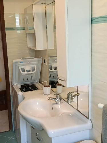 a bathroom with a sink and a microwave at Casa Sofia in Marina Julia