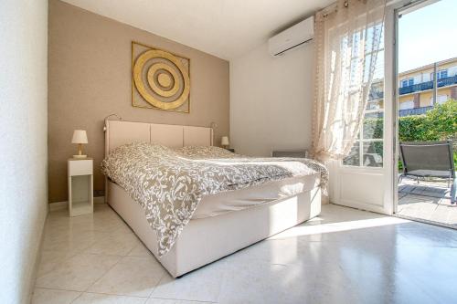 a bedroom with a bed and a large window at Le Charme bleu d'Azur in Saint-Raphaël