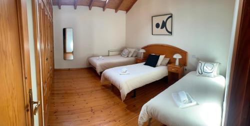 a room with three beds in a room at Escuelas de collía B AT-1537-AS in Arriondas