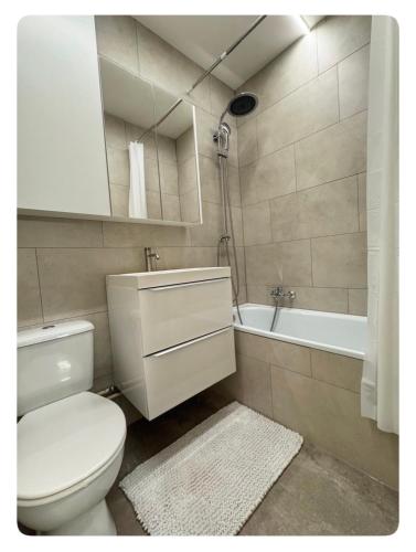 a bathroom with a toilet and a sink and a tub at Studio Palace 217 in Middelkerke