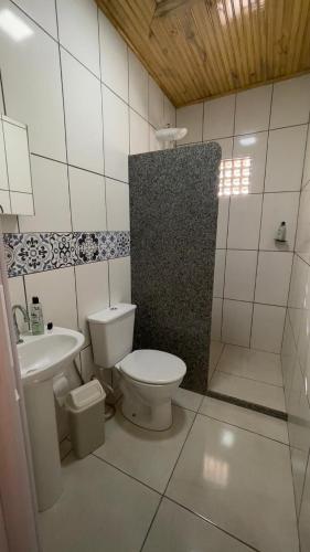 a white bathroom with a toilet and a sink at Pousada Ferrari Casa Nostra in Santa Teresa