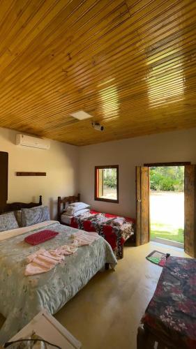 a bedroom with two beds and a wooden ceiling at Pousada Ferrari Casa Nostra in Santa Teresa