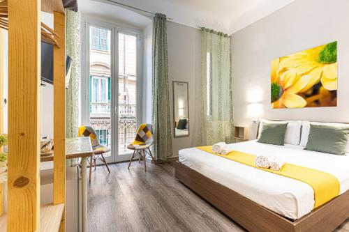 a bedroom with a bed and a desk and a window at Titi Rooms in La Spezia