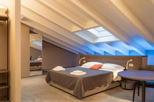 a bedroom with a bed and a table in it at Villa Eliseo Luxury Suites in Modena