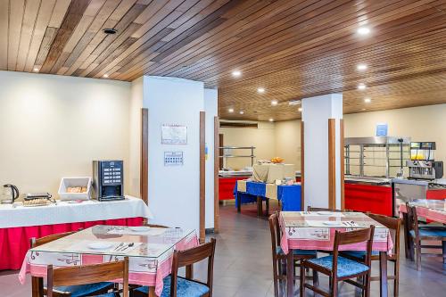 a restaurant with tables and chairs and a kitchen at HI São Pedro do Sul – Pousada de Juventude in Termas de Sao Pedro do Sul