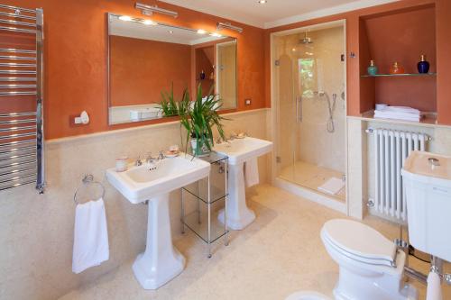 a bathroom with two sinks and a shower and a toilet at Castello di Roncade in Roncade