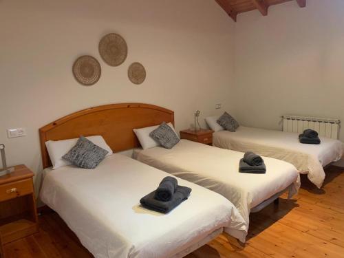 two beds with hats on top of them in a room at Escuelas de collía C AT-1537-AS in Arriondas