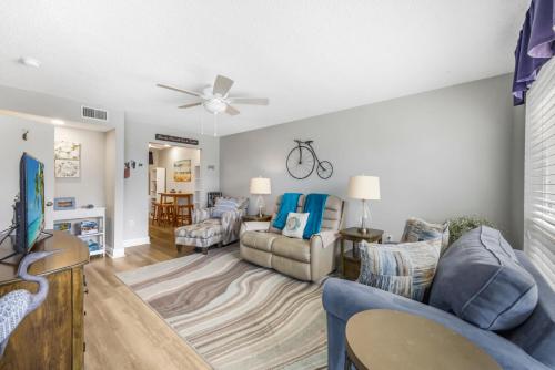 a living room with a blue couch and a ceiling fan at San Marco Villas H-3 in Marco Island