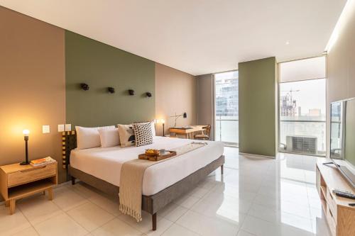 a bedroom with a large bed and a large window at Casa Reforma by Kukun in Mexico City